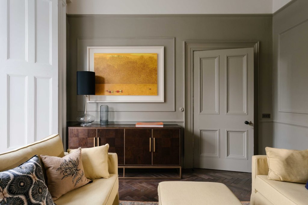 Living room interior photographed by Elyse Kennedy with sofa, side table, lamp and bright yellow art 